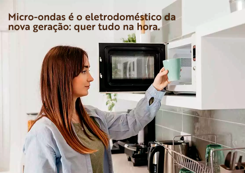 foto de uma moça colocando um prato no microondas.'